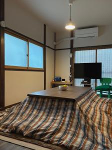 a large bed in a room with a tv at 亀のや in Tokyo