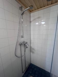 eine Dusche in einem weiß gefliesten Badezimmer in der Unterkunft Jauri Resort in Kemijärvi + 33 Fotos