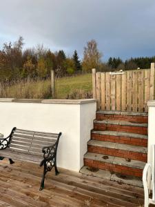 a bench sitting on a deck next to a fence at Glenburn Cottage in Kirkmichael +10 photos