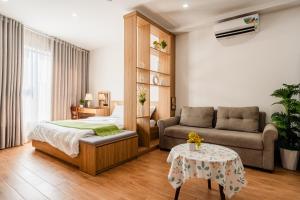 a bedroom with a bed and a couch and a table at Vari Homestay Đội Cấn in Hanoi