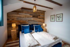 a bedroom with two beds and a wooden wall at Casa Mosului - Transfăgărășan Bed & Breakfast in Cîrţişoara