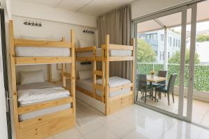 ケープタウンにあるSweetStay - Kloof Streetの二段ベッドと机とテーブルのある寮の部屋