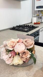 a bouquet of pink roses on a counter in a kitchen at Julia Militari Studio in Roşu