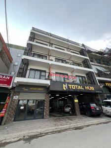 a tall hotel with cars parked in front of it at Vari Homestay Đội Cấn in Hanoi