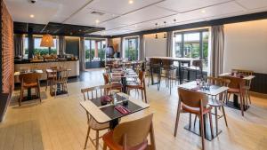 卡奥尔Campanile NATURE - Cahors的有桌椅和酒吧的餐厅