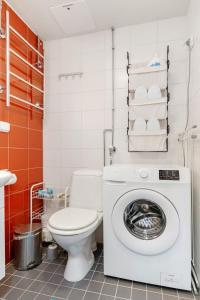 a bathroom with a toilet and a washing machine at Aurora Atelier in Rovaniemi