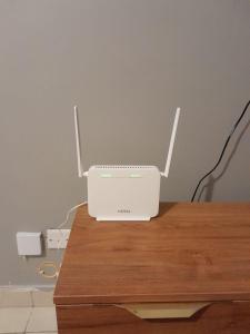a white router sitting on top of a wooden table at Tulia homes in Kanga