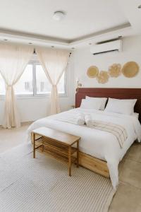 拉纳卡Kastella Blue Apartment Near Beach的一间白色的大卧室,配有一张大床和一张桌子