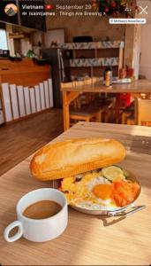 a sandwich on a table with a cup of coffee at Dalat Peace Backpackers Hostel in Da Lat