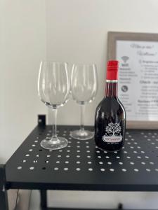 een fles wijn zittend op een tafel met drie wijnglazen bij Apartment Center Korça in Korçë +12 foto's