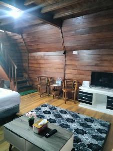 a room with a bed and a tv and a table at The Aisyah Cabin in Wonosobo +9 photos