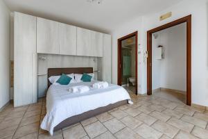 a bedroom with a large bed and a bathroom at Helios Vacanze in Conversano
