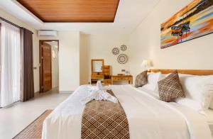 een slaapkamer met een groot wit bed in een kamer bij Okananda Villa Ubud in Ubud