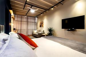 une chambre avec un grand lit et une télévision à écran plat dans l'établissement Copan Castelli Studios SP, à São Paulo