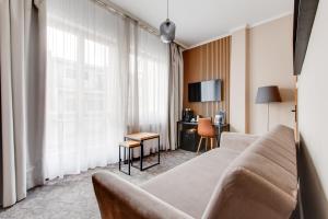 a living room with a couch and a desk at Hotel Andante in Prague