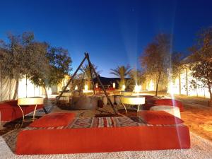 a room with a table and chairs and a swing at enjoy best night in desert merzouga in Merzouga +8 photos