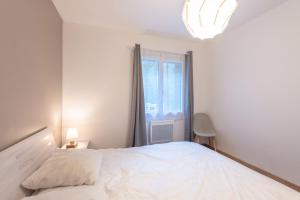 une chambre avec un grand lit blanc et une fenêtre dans l'établissement Chalets De L’arriutort 2 - Laruns, à Laruns