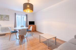 un salon avec une table, des chaises et un canapé dans l'établissement Chalets De L’arriutort 2 - Laruns, à Laruns 12 autres photos