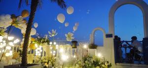 a room with a fence and a table with lights at Hando • Cape Seven Seaside Villa in Qingdao