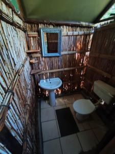 a small bathroom with a sink and a toilet at Amangwane Tented Camp in Enkovukeni