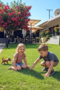 Dos niños jugando en el césped con un perro de juguete en Guest House Julia, en Stavros 24 fotos más