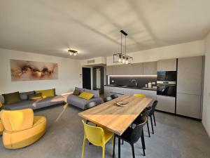a kitchen and living room with a wooden table and yellow chairs at Villa Tarca - Colico, Lake Como in Colico