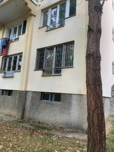 ein Gebäude mit vergitterten Fenstern und einem Baum in der Unterkunft Apartment Sarajevo in Sarajevo