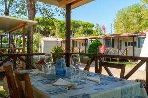 a table with glasses and napkins on a patio at Massa Marina Camping in Marina di Massa
