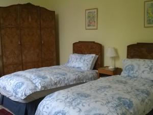 a bedroom with two beds with blue and white blankets at Glebe House Muston in Muston