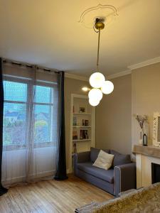 a living room with a blue couch and a window at Culture Maison Alençon in Alençon
