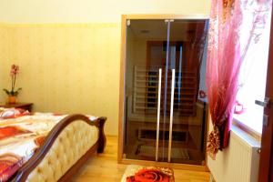 a bedroom with a bed and a glass door to a shower at Tatra Apartment Palace Hill with angels and sauna in Poprad