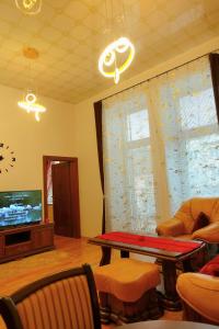 a living room with a table and a tv at Tatra Apartment Palace Hill with angels and sauna in Poprad