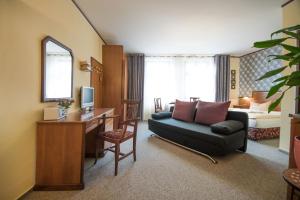 a living room with a couch and a desk with a television at Stadt Aparthaus in Waren