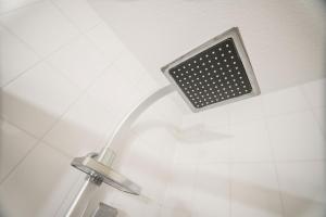 a shower with a shower head in a bathroom at Stadt Aparthaus in Waren +25 photos