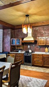 a kitchen with a chandelier and a table with chairs at Гостевой дом in Shymkent