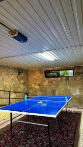 a ping pong table in a room with a stone wall at Гостевой дом in Shymkent +17 photos