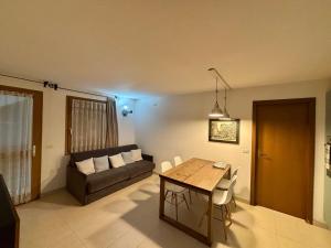a living room with a table and a couch at Pragma Apartments - Appartamento Dellantonio in Predazzo
