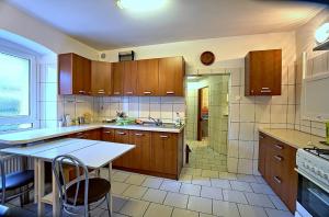 a large kitchen with wooden cabinets and a table at Dom Siedlisko Przesieka koło Karpacza in Przesieka +7 photos