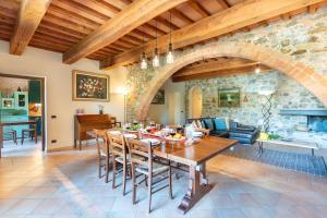 a dining room with a table and a stone wall at Pieve Vecchia, Luxury Tuscan Retreat with Spa in Campagnatico