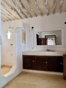 拉穆Nyumba ya mwezi的浴室里有洗手池和镜子