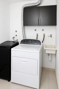 une laveuse et une sécheuse dans une salle de bain avec un lavabo dans l'établissement Bellini, Hermoso Departamento y 1 Plaza de Parqueo Gratis, à Guayaquil