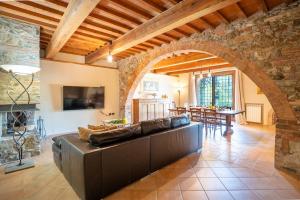 a living room with a large couch and a stone wall at Pieve Vecchia, Luxury Tuscan Retreat with Spa in Campagnatico