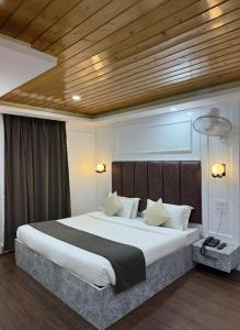 パハルガムにあるHotel crystalの木製の天井と大きなベッドのある寝室