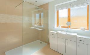 a bathroom with a glass shower and a sink at Vella in Lincoln