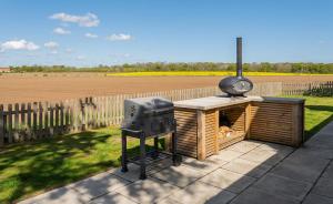 a barbecue grill and a smoker on a patio at Vella in Lincoln