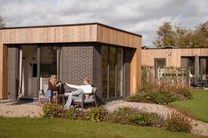 two women sitting in chairs outside of a house at Hofparken Wiltershaar in Winterswijk +88 photos
