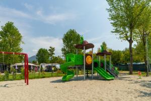 a playground with a green slide in the sand at Massa Marina Camping in Marina di Massa +48 photos