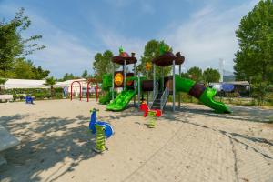 a park with a playground with a slide and play equipment at Massa Marina Camping in Marina di Massa