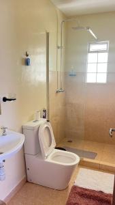 a bathroom with a toilet and a glass shower at Frost Haven in Eldoret