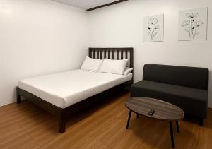 a small bedroom with a bed and a stool at Balai de Biday 4 Pax Suite with Breakfast Option in Mameltac